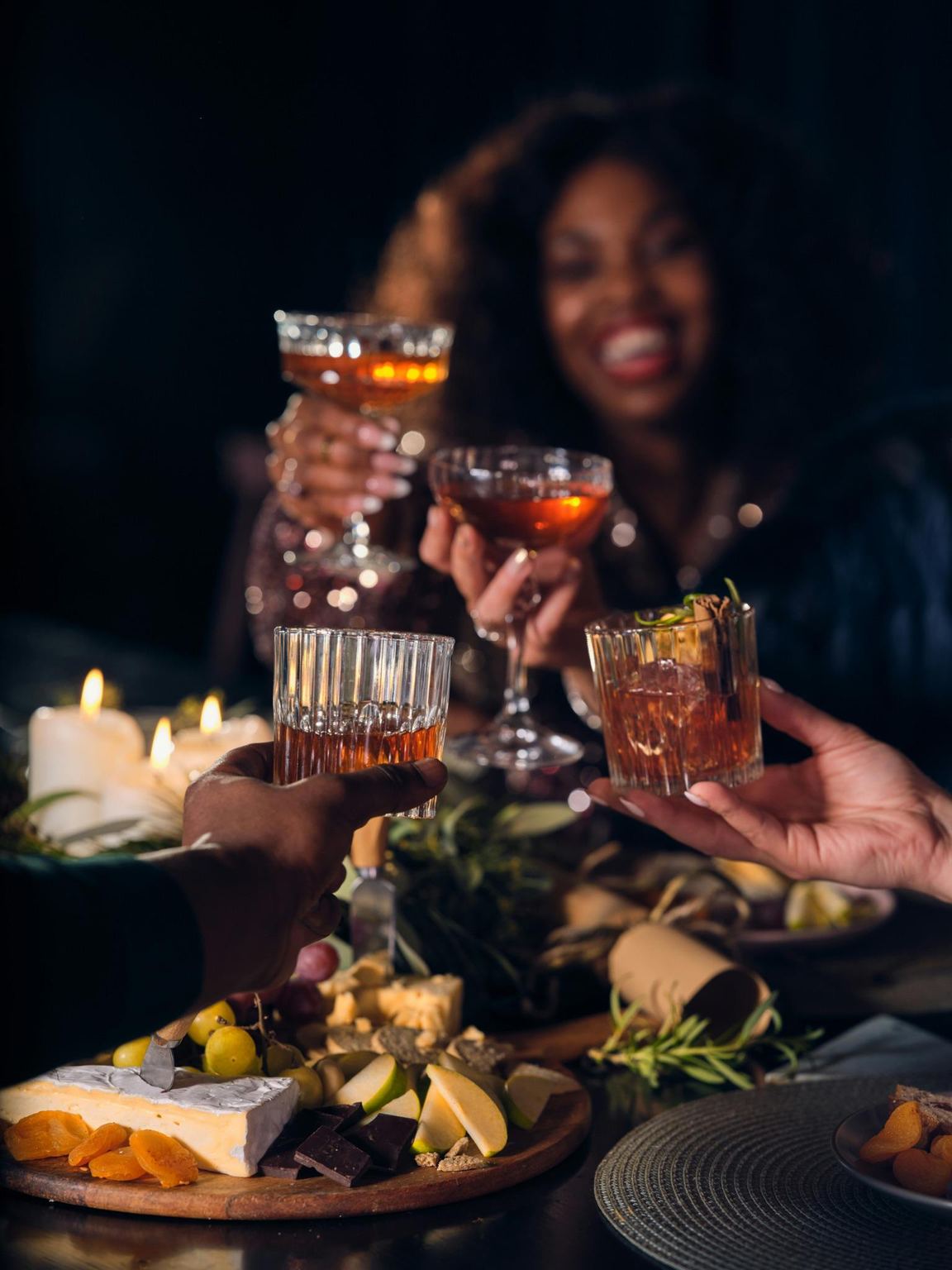 Friends raising glasses over a candlelit dinner table